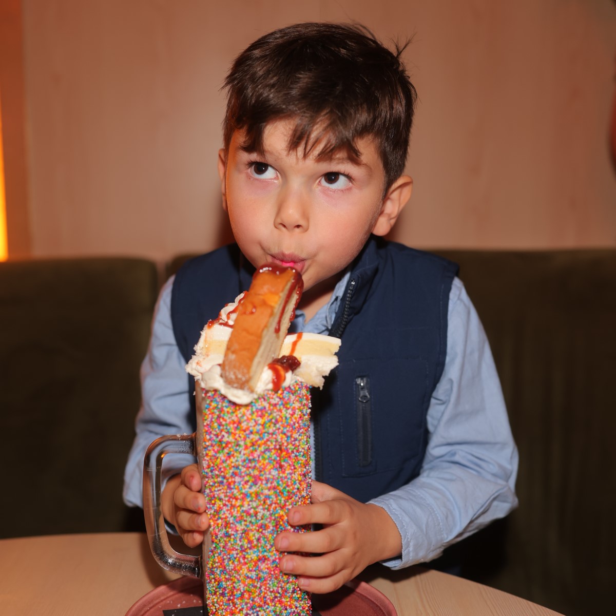 Young boy enjoying an over-the-top milkshake at Cafe Bombon.